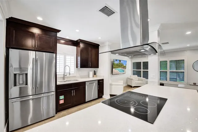 a kitchen with stainless steel appliances granite countertop a refrigerator a sink and a stove