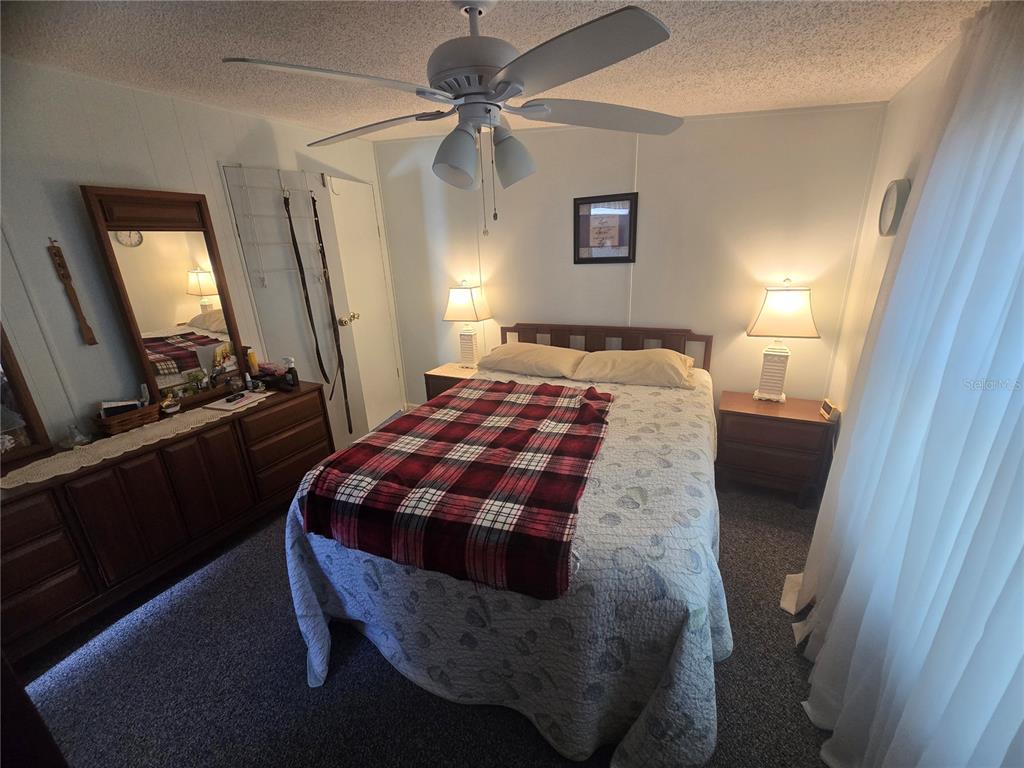 1710 7th Street Southwest, Unit 59 Ruskin, FL 33570 - Photo 13 of 31 a bedroom with a bed and a mirror on dresser