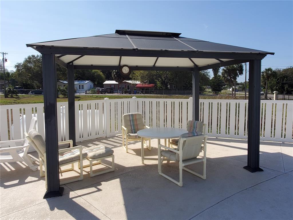 1710 7th Street Southwest, Unit 59 Ruskin, FL 33570 - Photo 28 of 31 a patio with glass top table and chairs