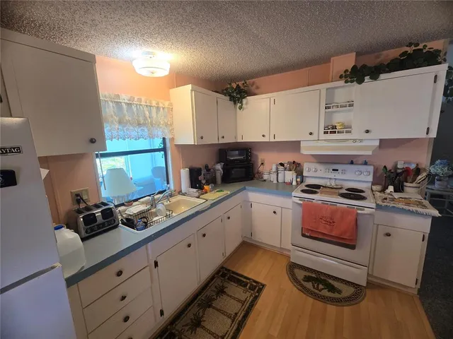 a kitchen with granite countertop a stove sink and cabinets