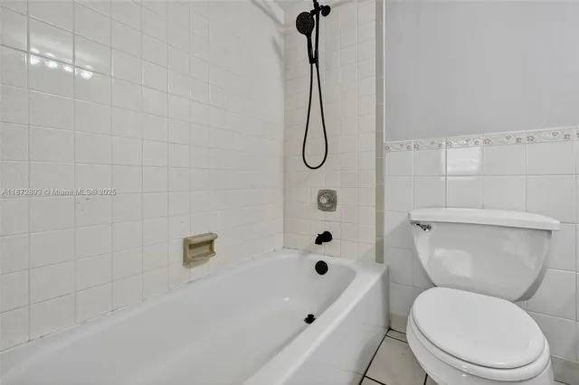 a white toilet sitting next to a bath tub shower