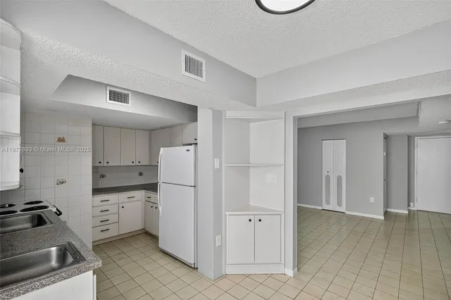 a kitchen with stainless steel appliances a refrigerator and a stove top oven