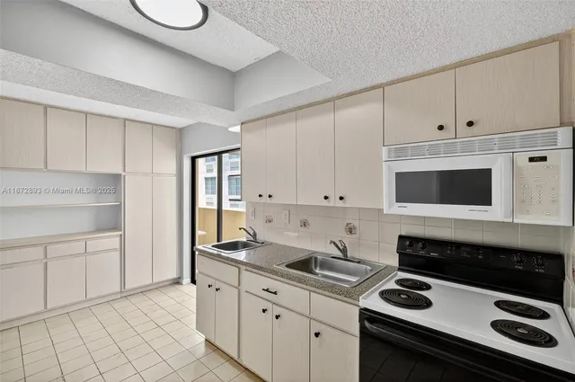 a kitchen with granite countertop white cabinets and white appliances
