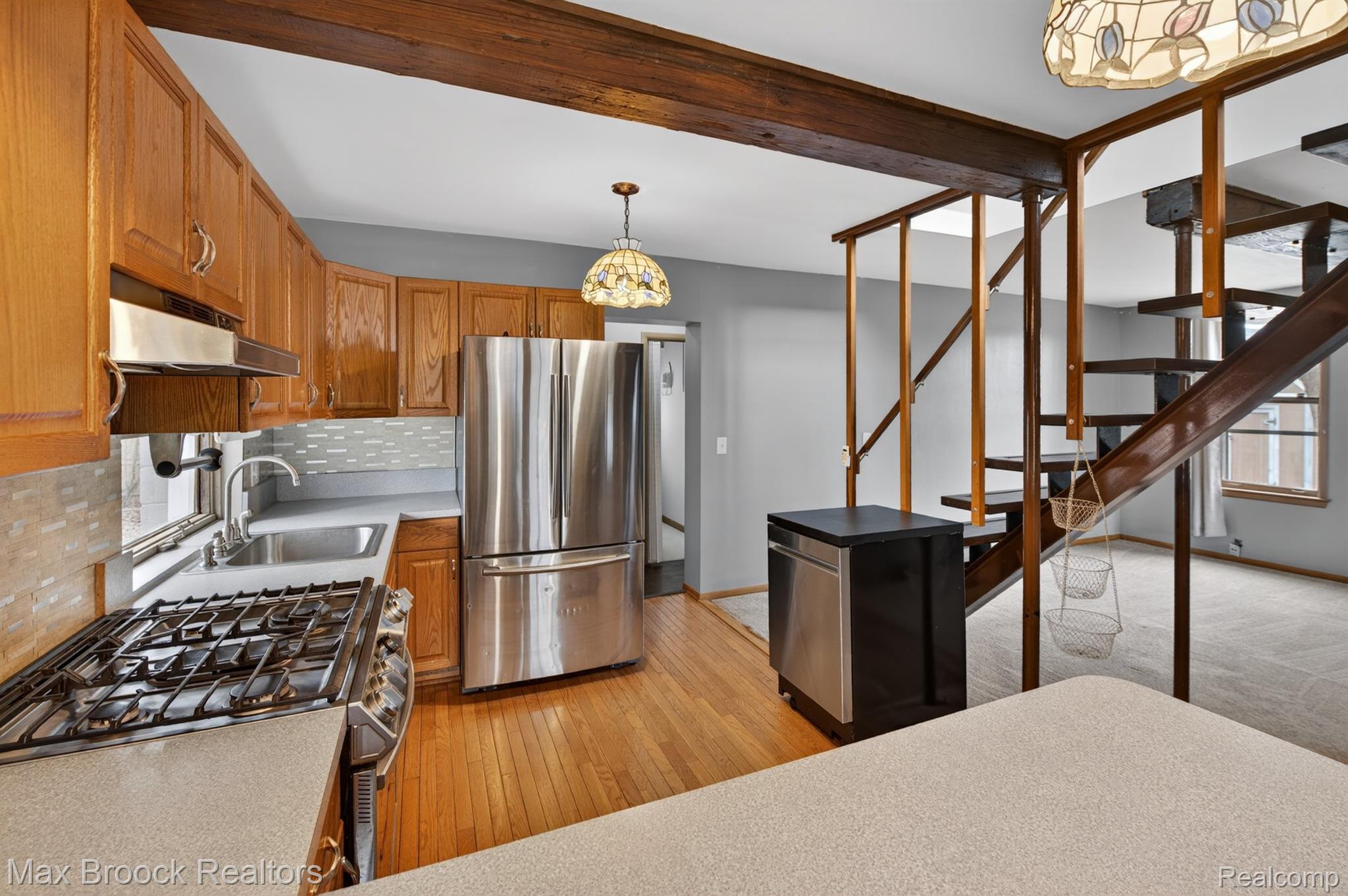 9024 Mandon Road White Lake, MI 48386 - Photo 11 of 39 Kitchen featuring light countertops, stainless steel appliances, pendant lighting, decorative backsplash, and wood finish cabinetry
