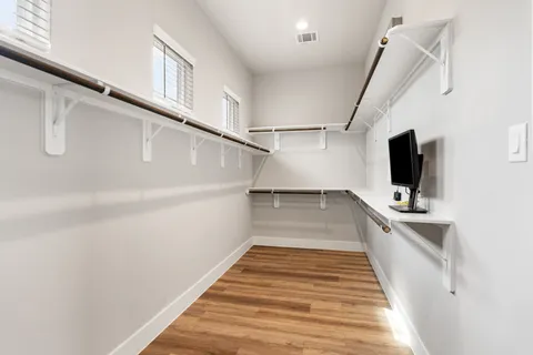 an empty room with wooden floor and windows