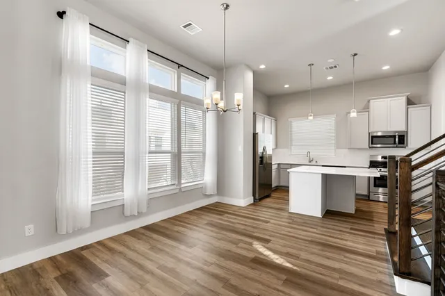 a kitchen with kitchen island a counter top space cabinets and stainless steel appliances
