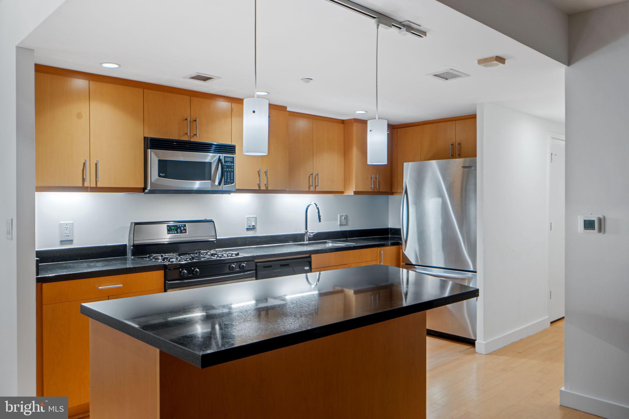912 F Street Northwest, Unit 508 Washington, DC 20004 - Photo 11 of 40 a kitchen with stainless steel appliances granite countertop a sink a refrigerator and a stove
