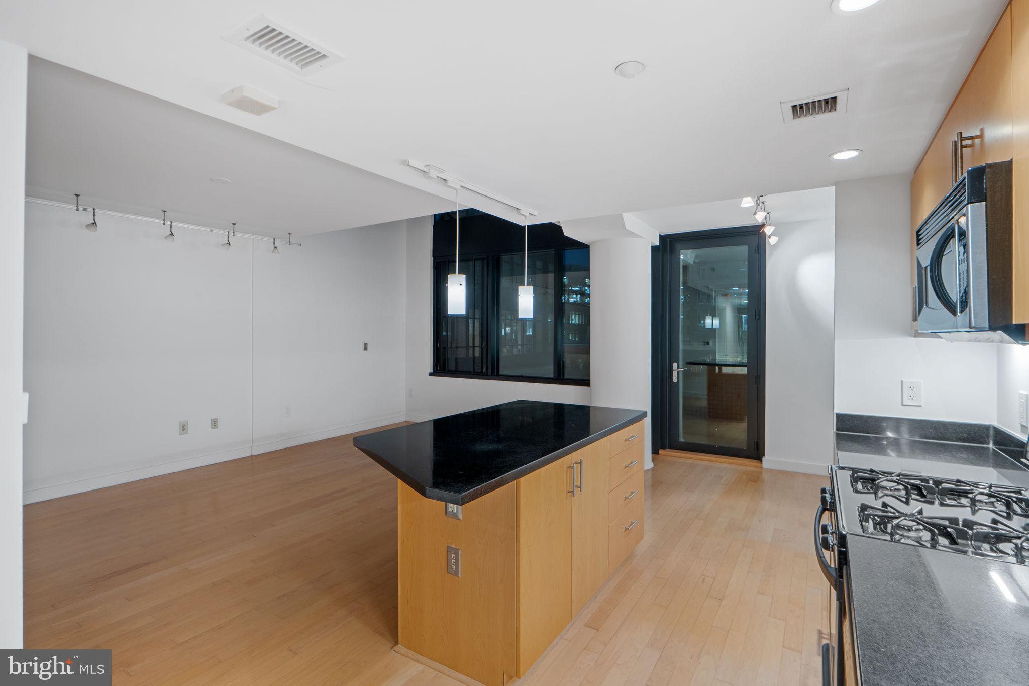 912 F Street Northwest, Unit 508 Washington, DC 20004 - Photo 14 of 40 a living room with stainless steel appliances kitchen island granite countertop a refrigerator and a sink