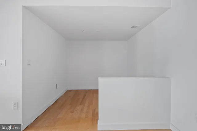 a living room with furniture a bookshelf and a potted plant