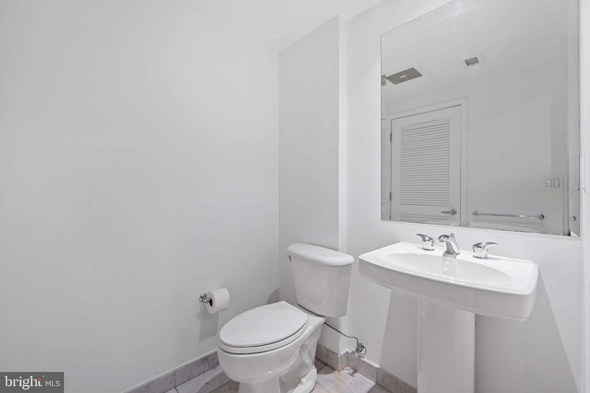 912 F Street Northwest, Unit 508 Washington, DC 20004 - Photo 27 of 40 a bathroom with a sink toilet and a mirror