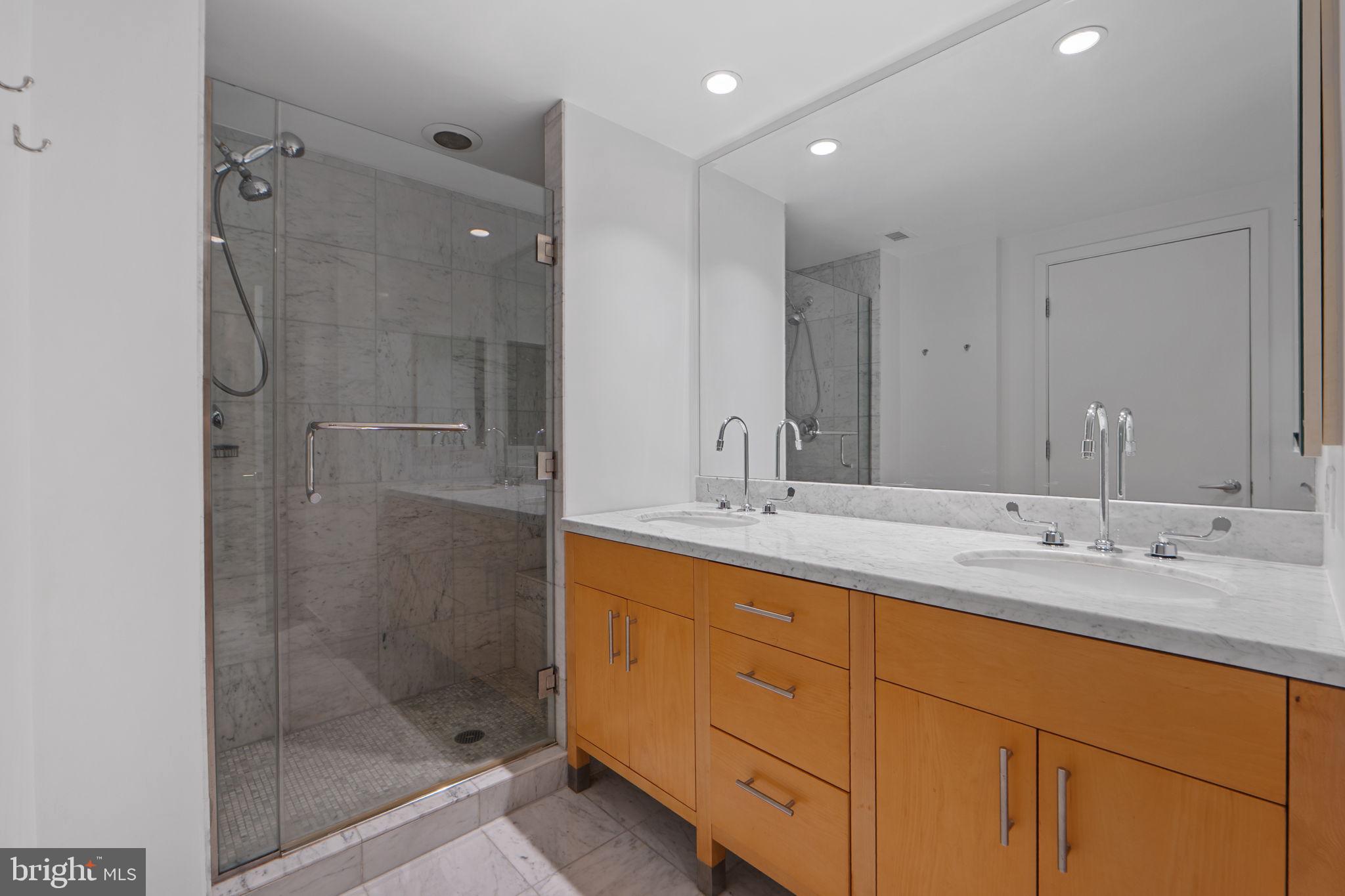 912 F Street Northwest, Unit 508 Washington, DC 20004 - Photo 34 of 40 a bathroom with a double vanity sink mirror and shower