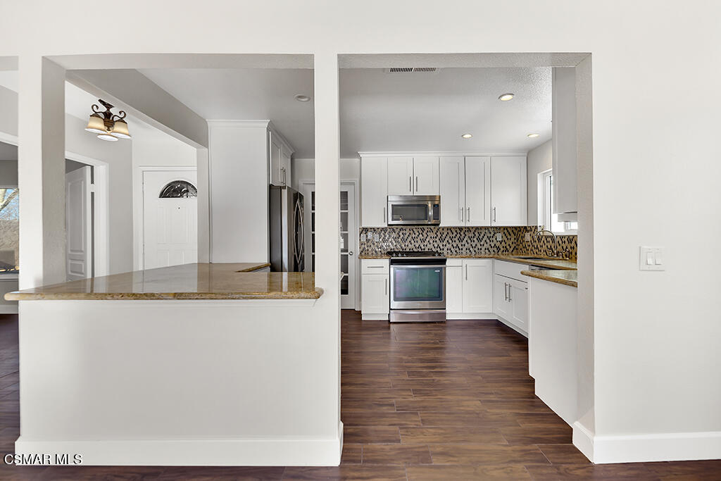 39202 Willowvale Road Palmdale, CA 93551 - Photo 11 of 36 a large kitchen with cabinets and wooden floor