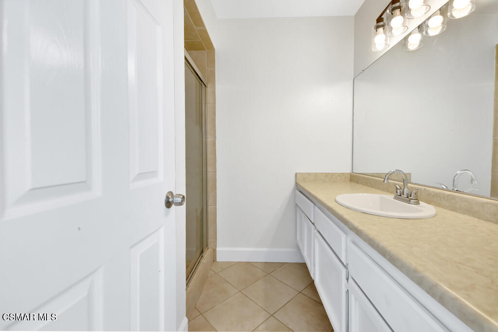 39202 Willowvale Road Palmdale, CA 93551 - Photo 19 of 36 a bathroom with a granite countertop sink and a mirror