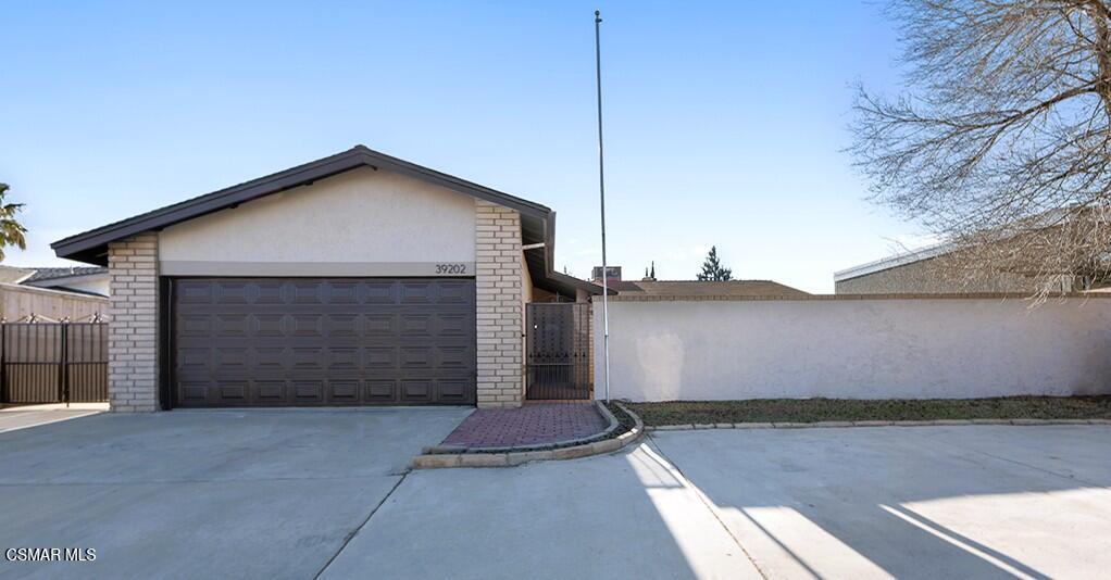 39202 Willowvale Road Palmdale, CA 93551 - Photo 28 of 36 a front view of a house with a yard and garage