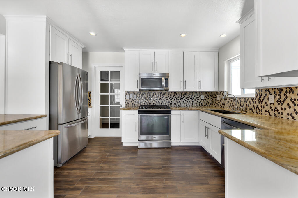 39202 Willowvale Road Palmdale, CA 93551 - Photo 3 of 36 a kitchen with granite countertop white cabinets and stainless steel appliances
