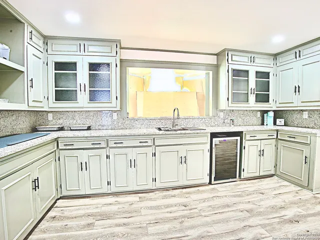 a kitchen with granite countertop a sink stove and cabinets