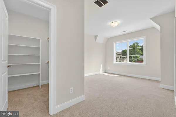 a view of a house with a large window and a yard with wooden fence