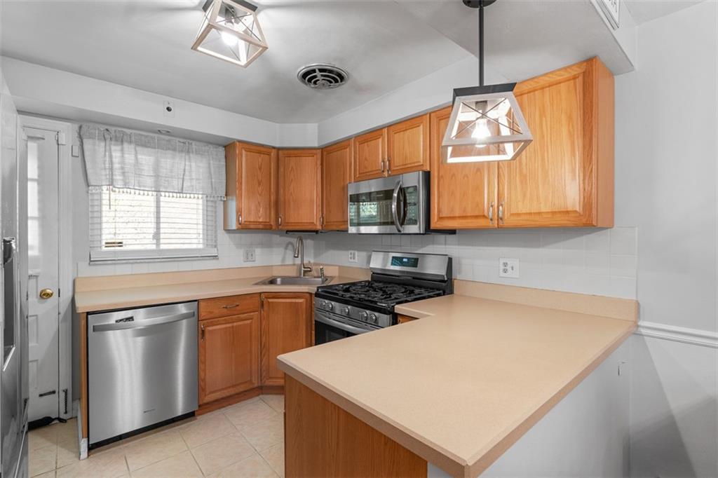 1538 Rutherford Avenue Pittsburgh, PA 15216 - Photo 24 of 43 a kitchen with stainless steel appliances granite countertop a stove a sink and a microwave