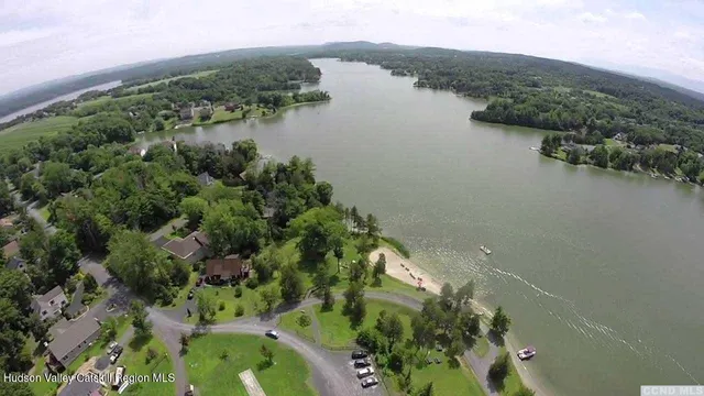 an aerial view of green landscape with trees houses and lake view