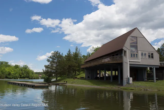 a view of a lake with a big yard and large trees