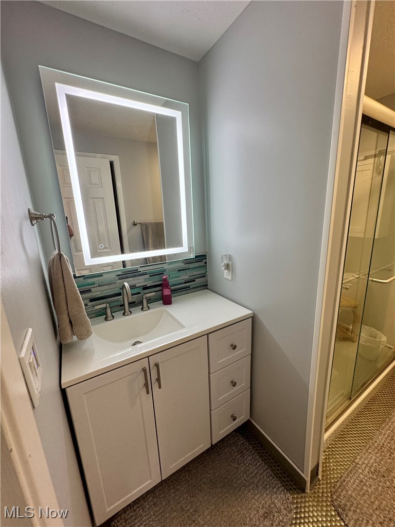 8949 West Ridge Road, Unit B Elyria, OH 44035 - Photo 19 of 24 Bathroom with vanity, a shower stall, and tasteful backsplash