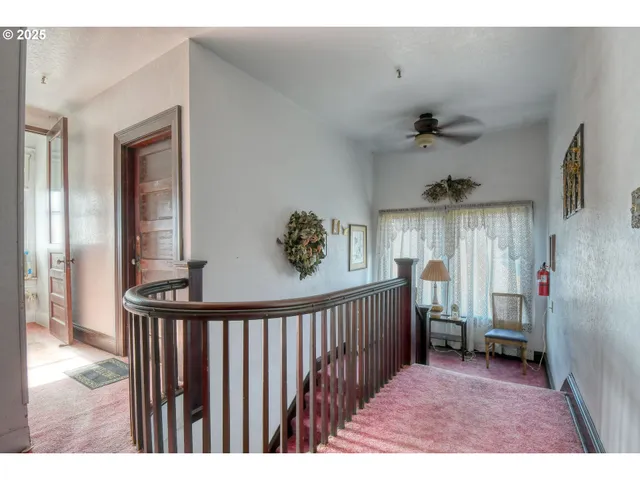 a view of a hallway to a bedroom with windows