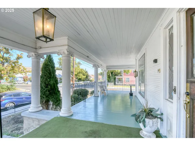 a view of a living room with a floor to ceiling window and wooden floor