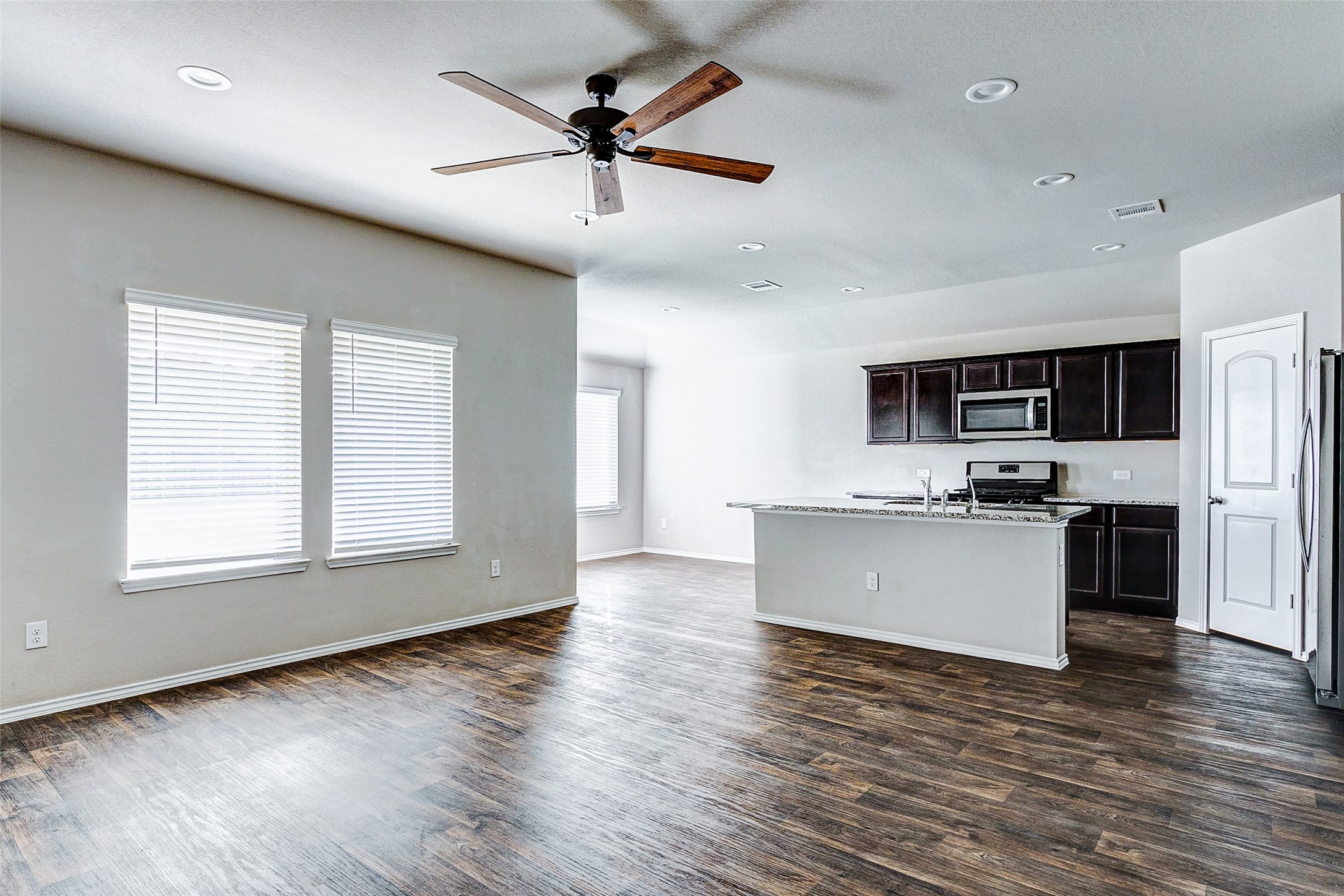 40454 Red Poppy Lane Magnolia, TX 77354 - Photo 4 of 23 a kitchen with stainless steel appliances granite countertop a stove top oven a sink dishwasher a refrigerator and white cabinets with wooden floor