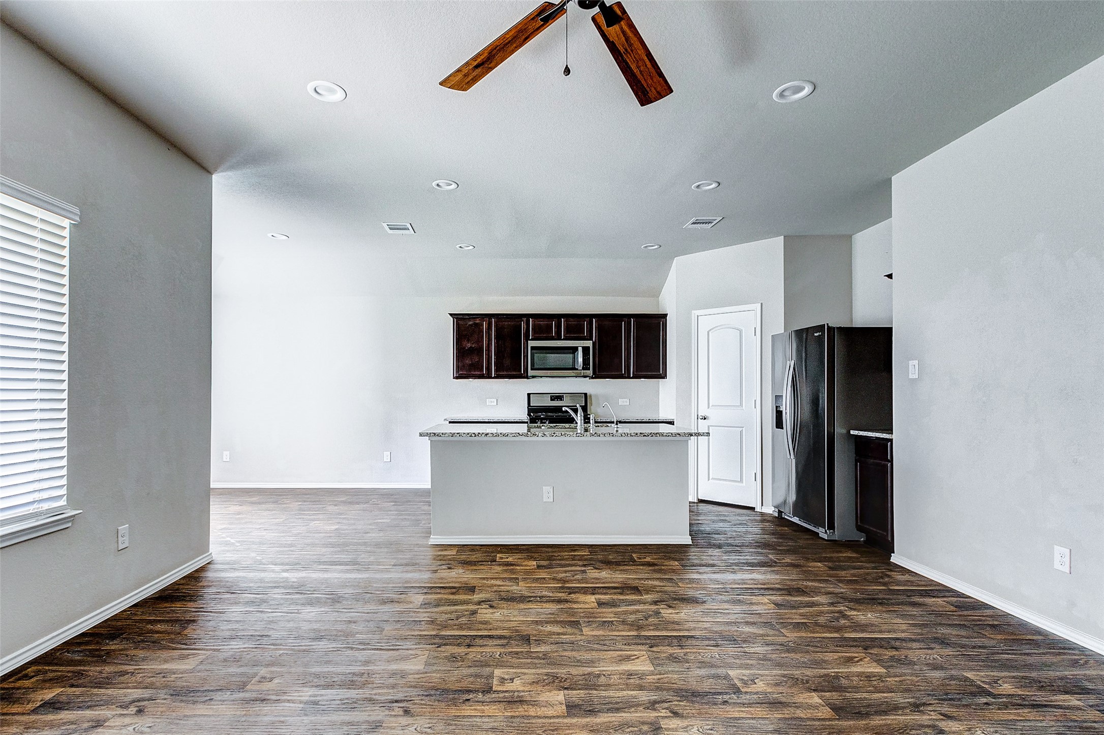 40454 Red Poppy Lane Magnolia, TX 77354 - Photo 5 of 23 a view of kitchen with refrigerator microwave and stove with wooden floor