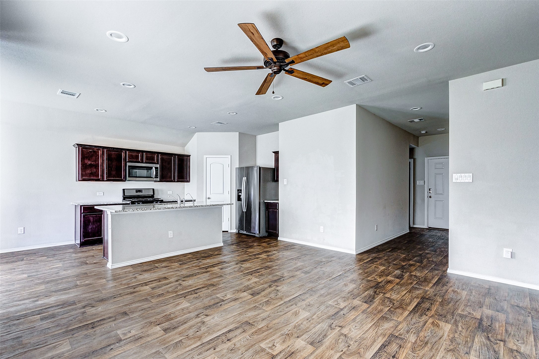 40454 Red Poppy Lane Magnolia, TX 77354 - Photo 6 of 23 a kitchen with stainless steel appliances kitchen island a refrigerator sink and fireplace