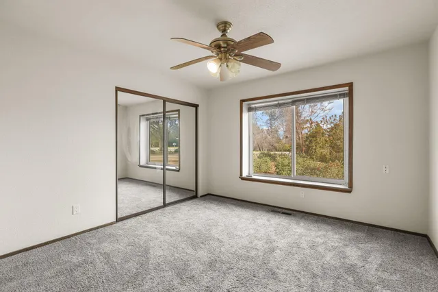 a view of a room with window and a ceiling fan