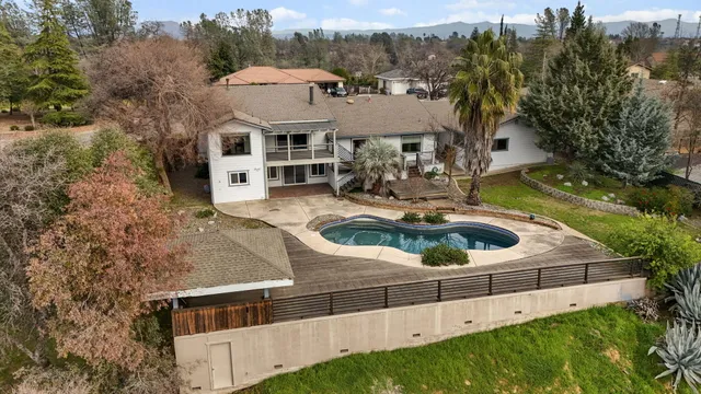 an aerial view of a house with swimming pool and garden