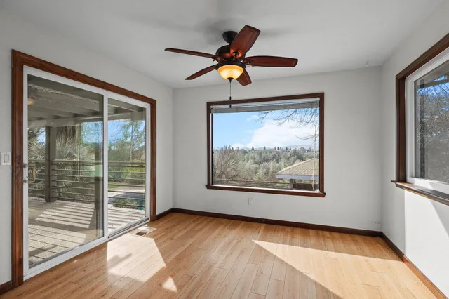 a view of a white house with a large trees