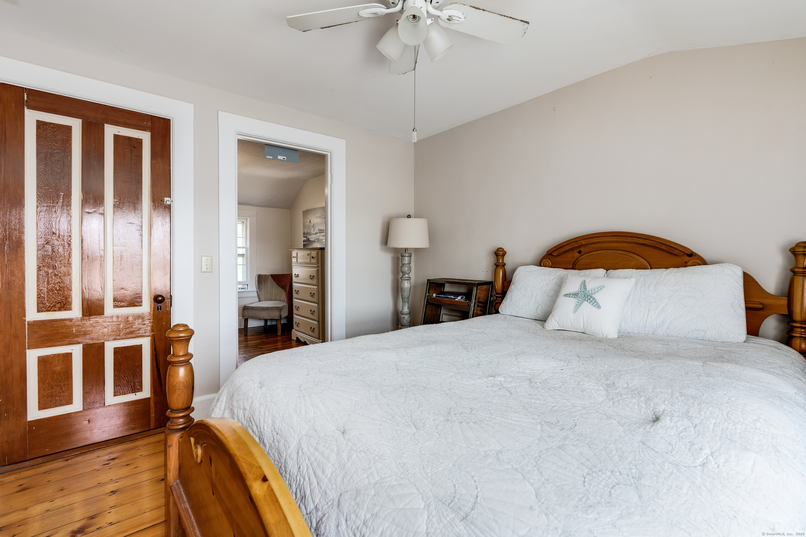 417 River Road Stonington, CT 06379 - Photo 28 of 39 a bedroom with a bed and a chandelier