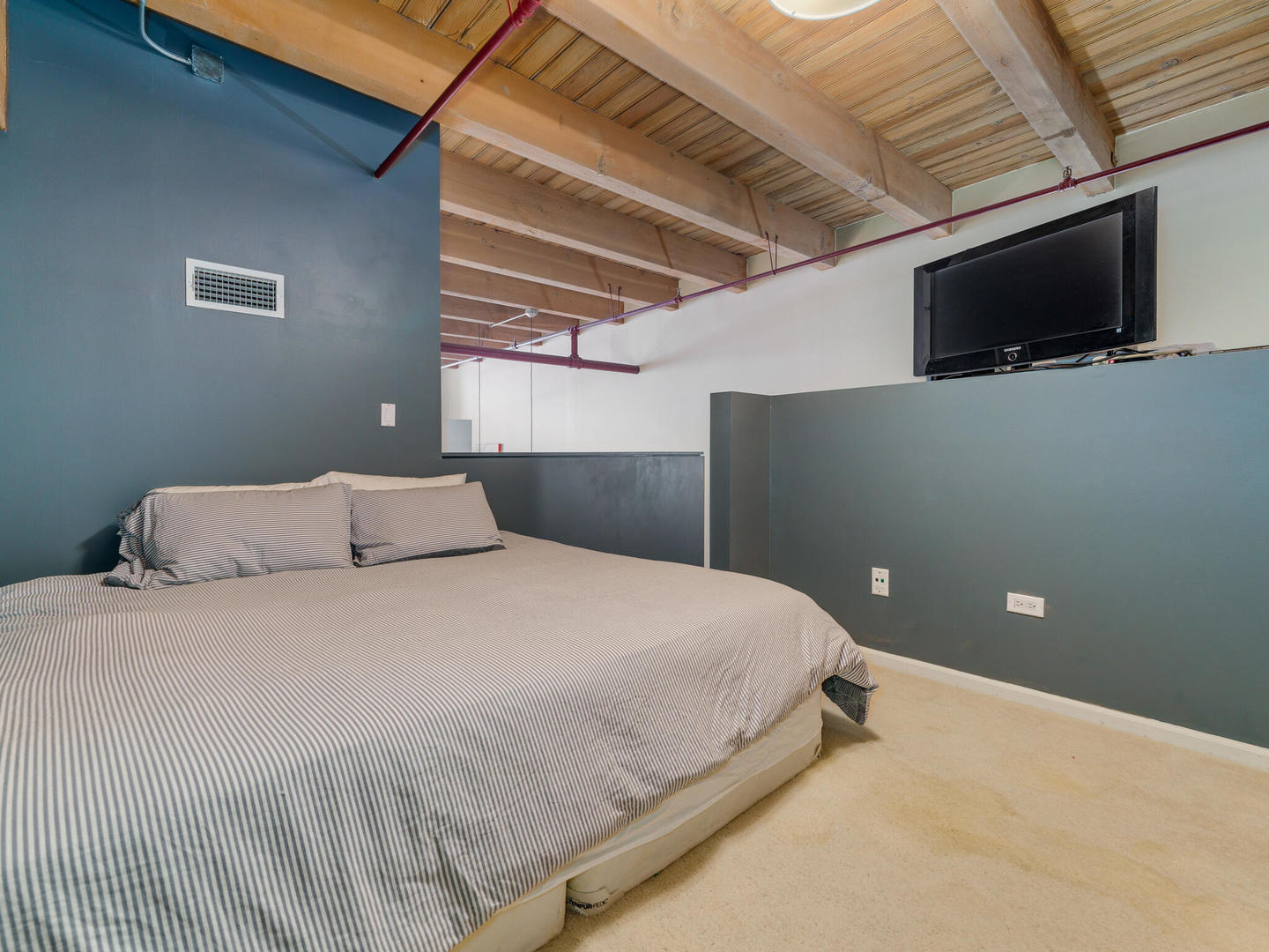 1733 West Irving Park Road, Unit 306 Chicago, IL 60613 - Photo 12 of 15 a bedroom with a bed and a flat screen tv