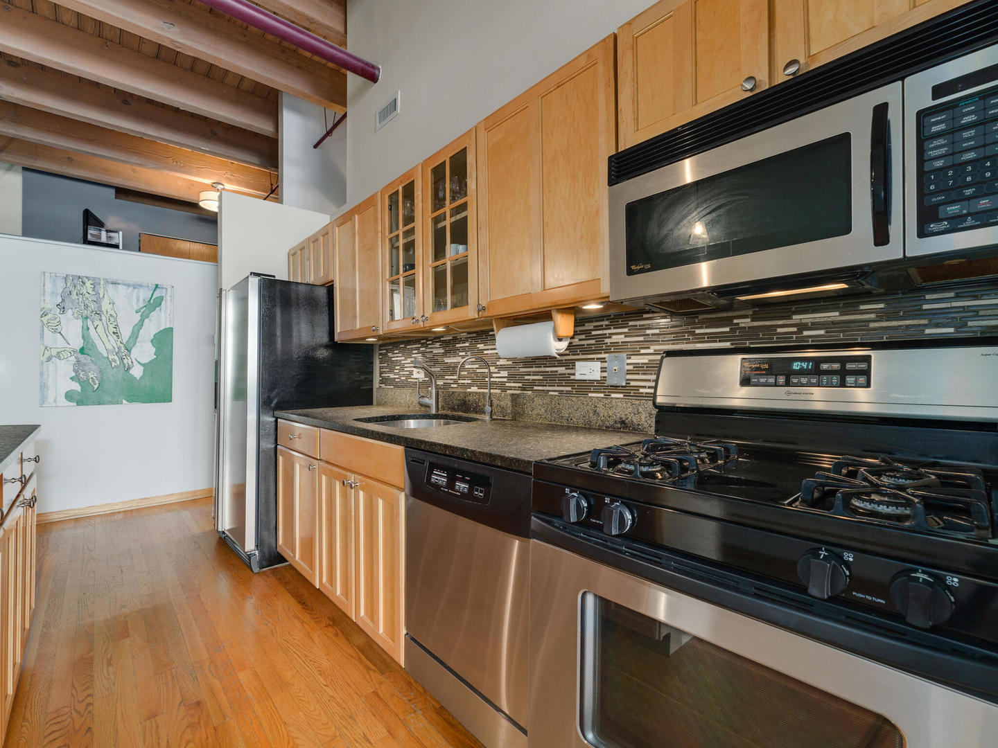 1733 West Irving Park Road, Unit 306 Chicago, IL 60613 - Photo 8 of 15 a kitchen with stainless steel appliances a stove a microwave and cabinets