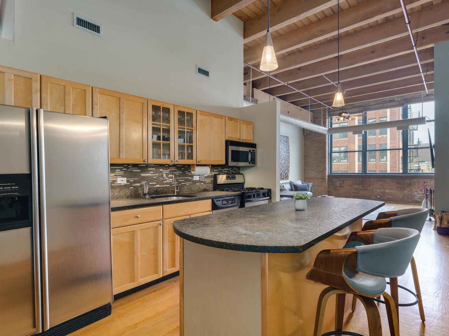1733 West Irving Park Road, Unit 306 Chicago, IL 60613 - Photo 9 of 15 a kitchen with stainless steel appliances granite countertop a sink a microwave and refrigerator