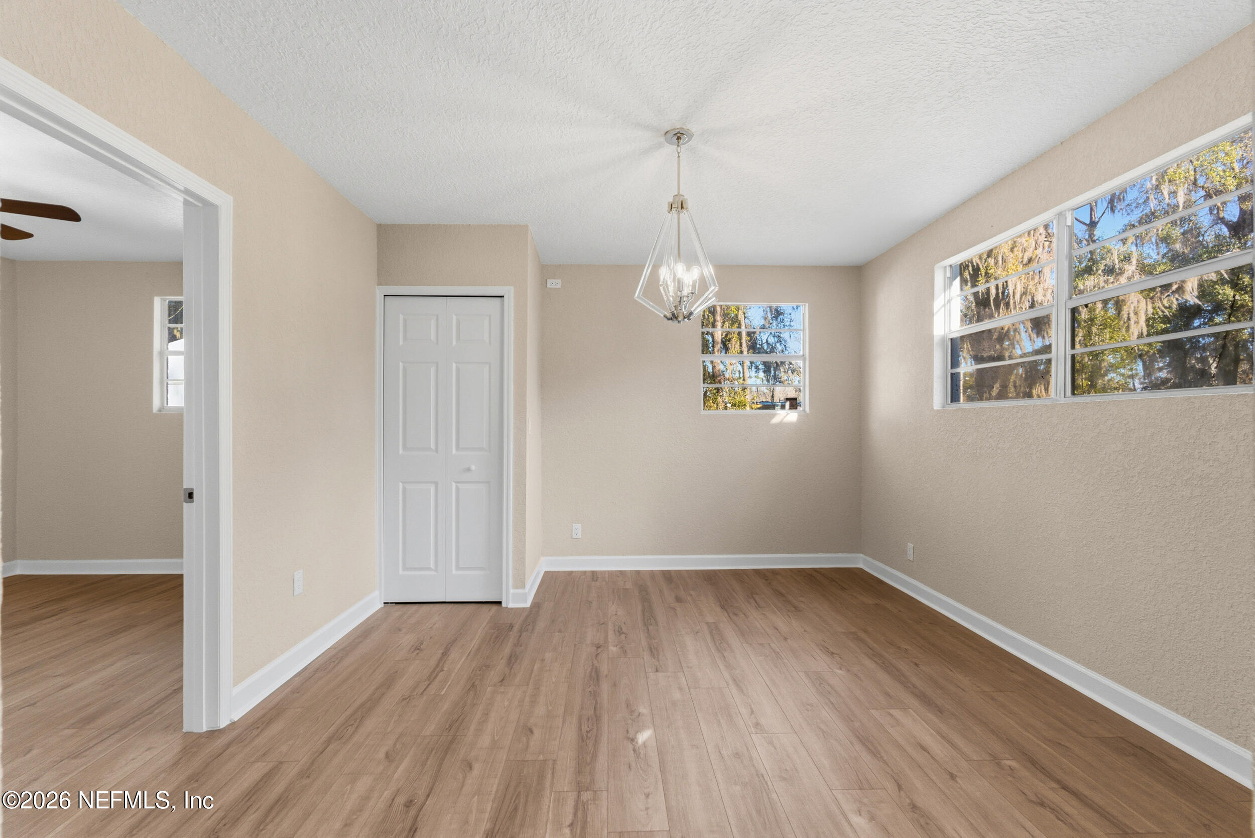 10531 Rutgers Road Jacksonville, FL 32218 - Photo 12 of 32 a view of empty room with wooden floor and window