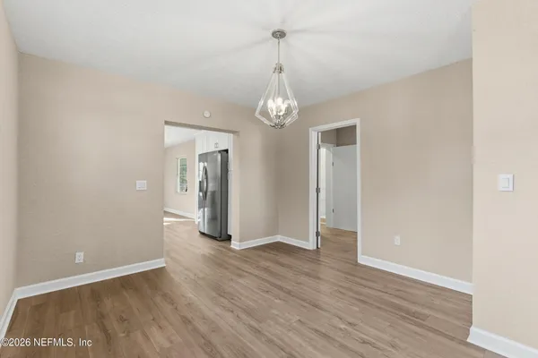 a view of empty room with wooden floor and window