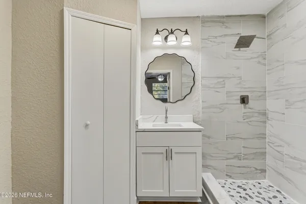 a bathroom with a sink a toilet and shower