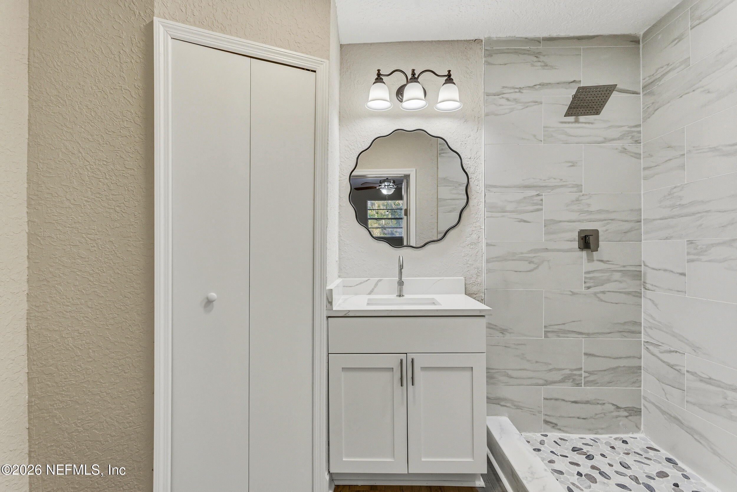10531 Rutgers Road Jacksonville, FL 32218 - Photo 18 of 32 a bathroom with a sink a mirror and a shower