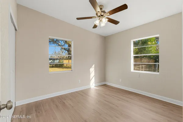a view of an empty room with wooden floor