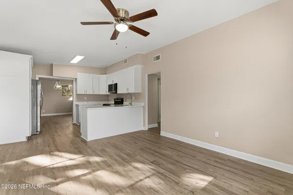 a kitchen with stainless steel appliances a refrigerator sink and white cabinets