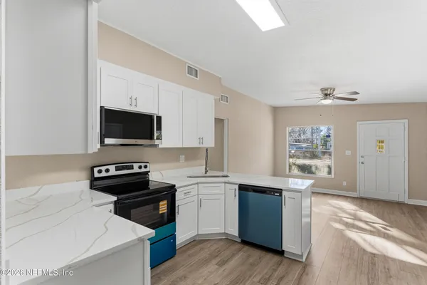 a metallic refrigerator freezer sitting in a kitchen