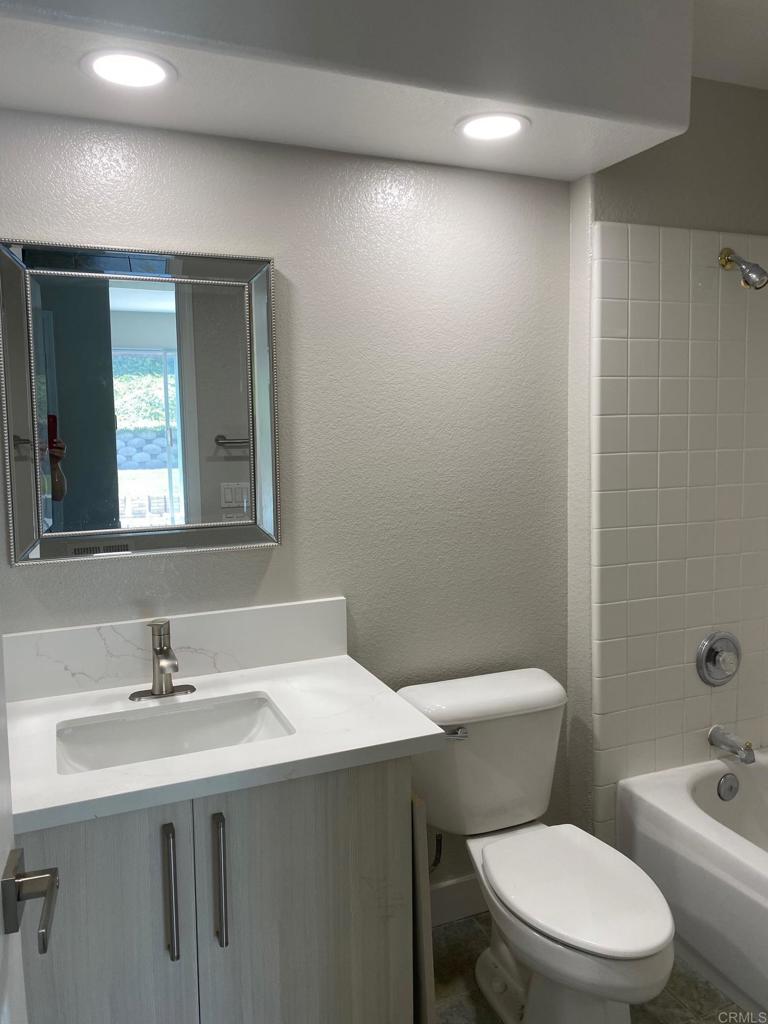 a bathroom with a sink a toilet and mirror