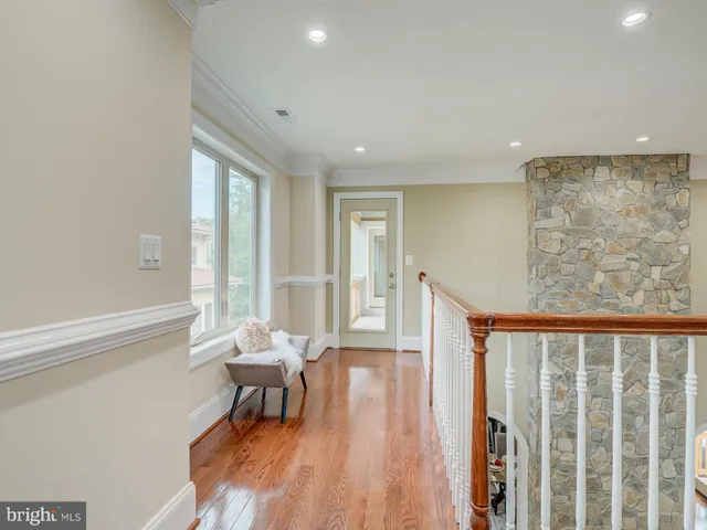 a view of an empty room with glass door and wooden floor