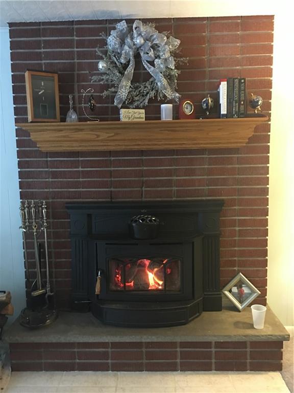118 Beacon Road Renfrew, PA 16053 - Photo 10 of 24 How rare is this? A beautiful brick fireplace and mantle with a heavy duty wood burner to crank up the heat during the cold days in the year.