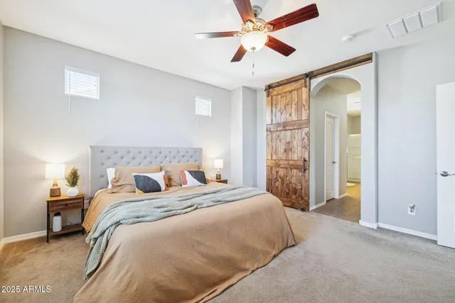 a bedroom with a large bed and a chandelier