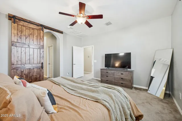 a bedroom with a bed a flat screen tv and a couch