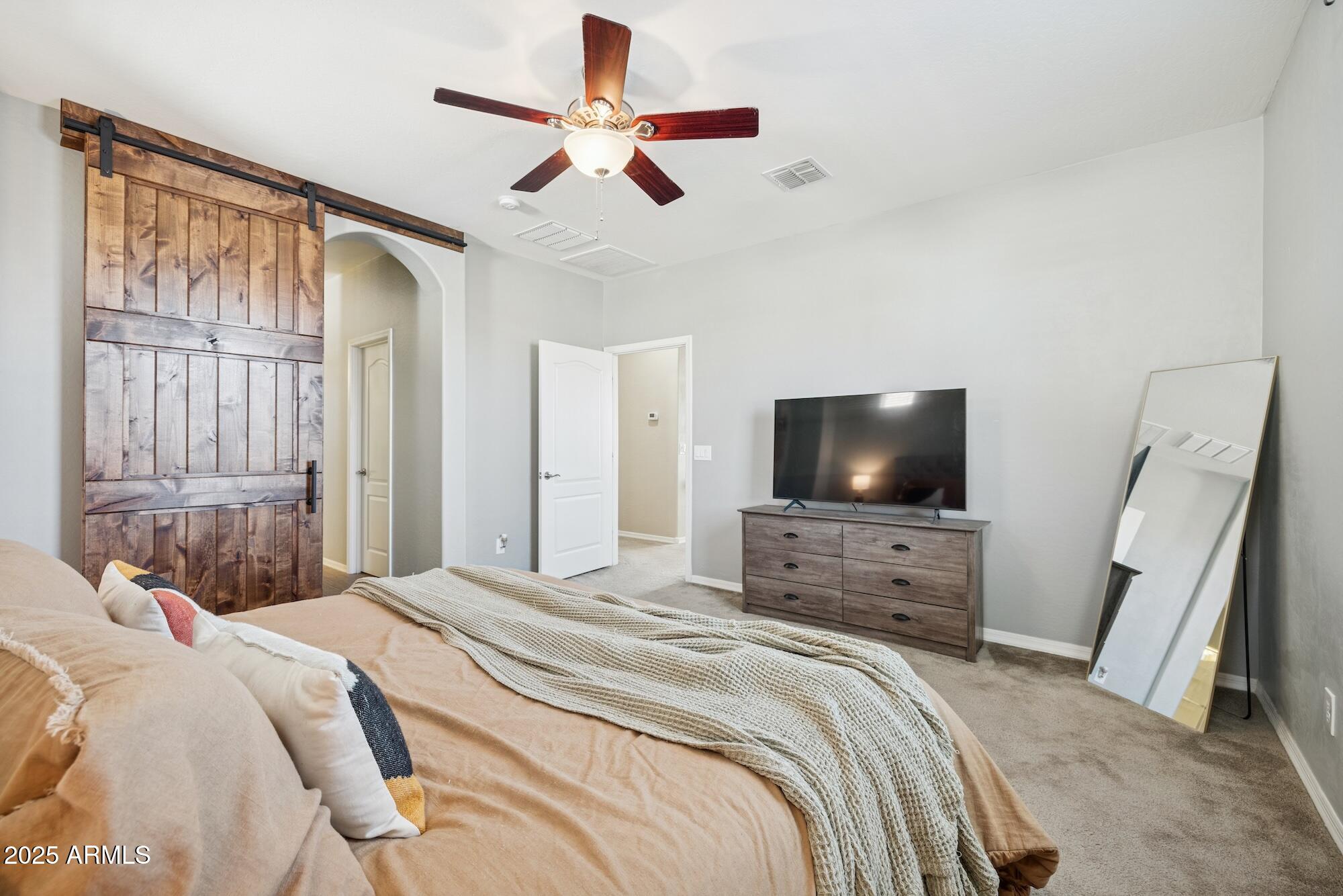 4124 East Toledo Street Gilbert, AZ 85295 - Photo 15 of 33 a bedroom with a bed a flat screen tv and a couch